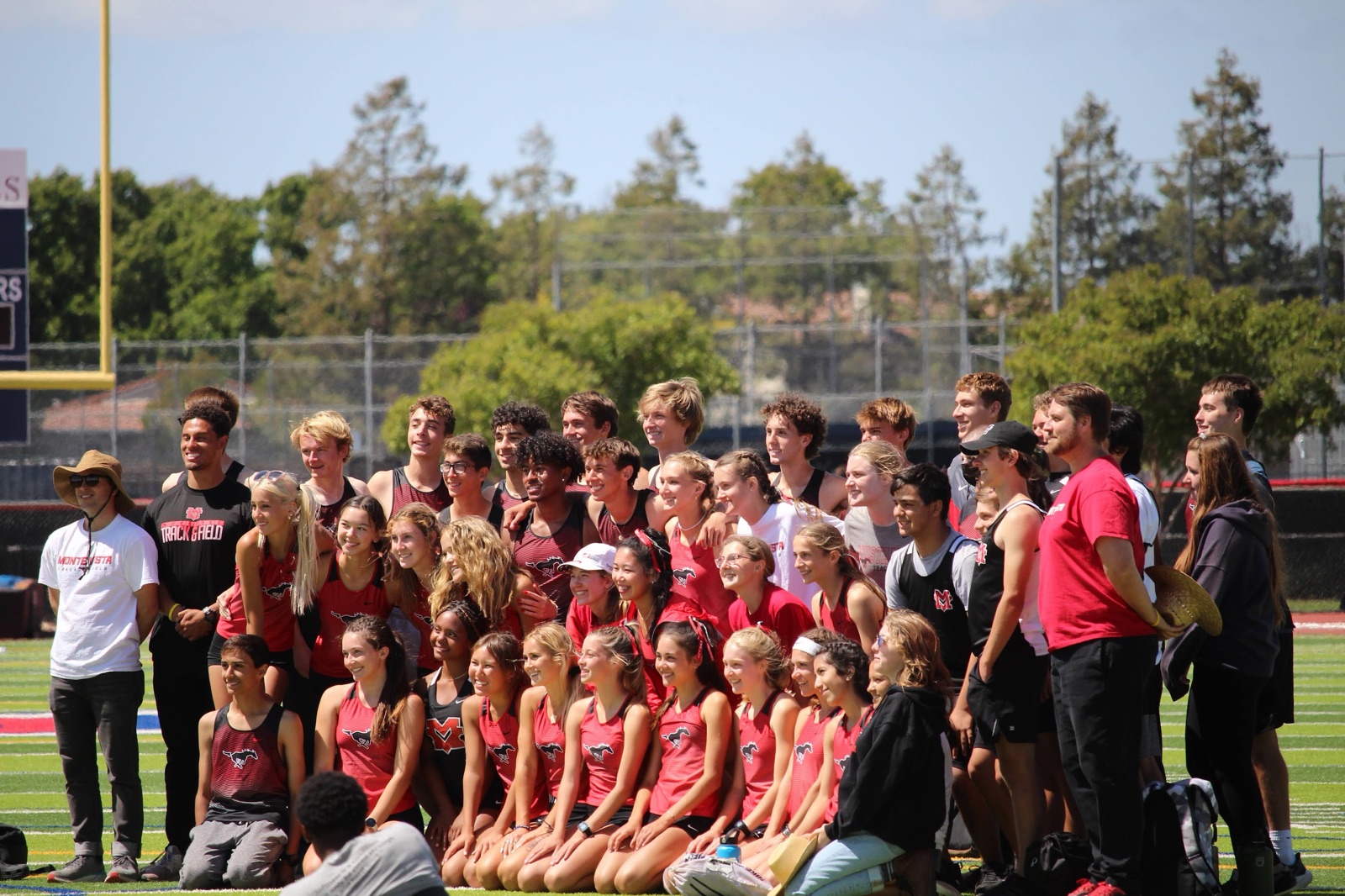 About fifty Monte Vista track and field athletes and coaches posed on the infield.